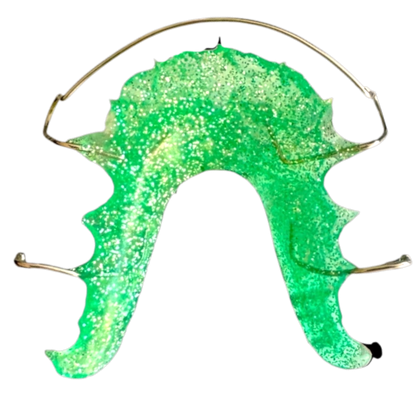Green glittery retainer with gold arch bow on a white background